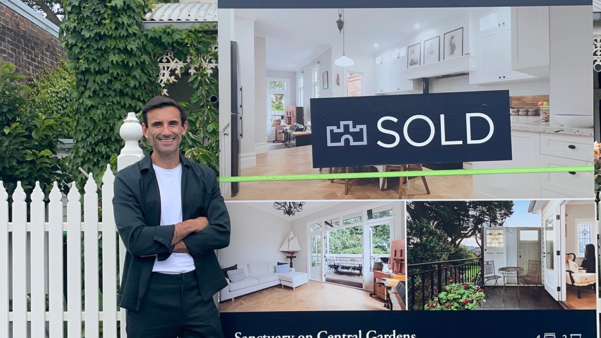A buyer's advocate standing next to a sold house