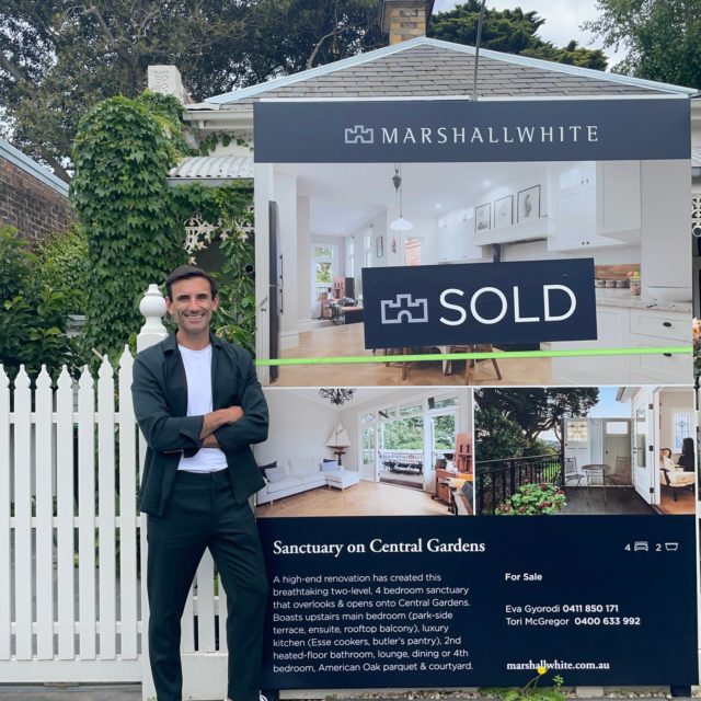 A buyer's advocate standing next to a sold house